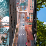 Entertainment Retail Anchors, Commercial Location Strategy, and Billionaires’ Row Vacancies. Image of the inside of a shopping mall (left), a city street from a bird's eye view (middle), and buildings on Billionaires' Row in New York City (right).